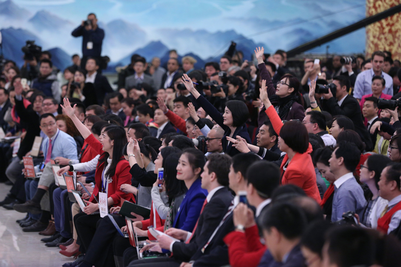 3月15日，國務院總理李克強在北京人民大會堂與中外記者見面，并回答記者提問。這是記者舉手爭取提問機會。 新華社記者 才揚 攝