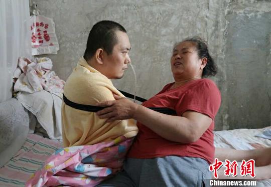 身體日漸衰老的梁青蘭每次幫兒子翻身、坐立，全身的衣物都要濕透一次?！∩忻鱾b 攝