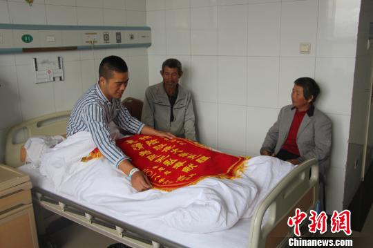 被救的李忠起、張總鳳夫婦看望受傷后的李運(yùn)飛?！⊥粲?攝