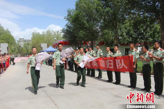 部隊(duì)官兵們迎接出院歸來的李運(yùn)飛(中)和其他消防戰(zhàn)士?！⊥粲?攝
