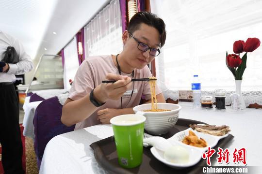 圖為旅客在列車上享用正宗牛肉面?！钇G敏 攝