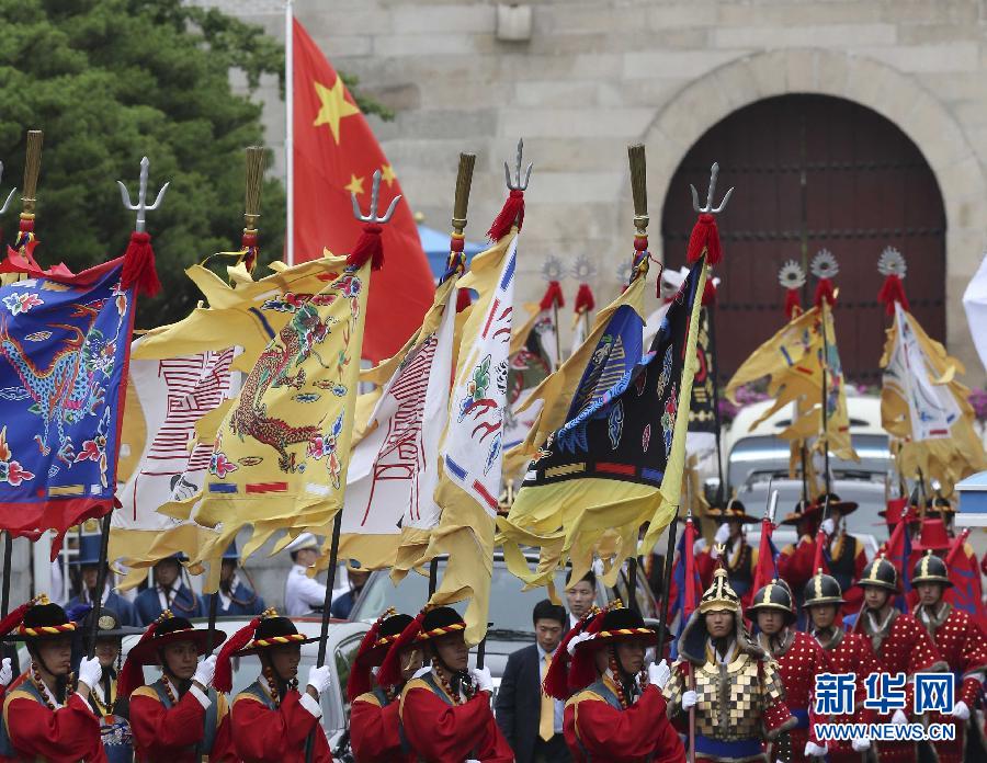 7月3日，韓國總統(tǒng)樸槿惠在青瓦臺總統(tǒng)府舉行隆重儀式，歡迎中國國家主席習近平對韓國進行國事訪問。這是習近平的車隊在身著民族服裝的韓國禮儀隊伍引導下駛入青瓦臺。新華社記者丁林攝  