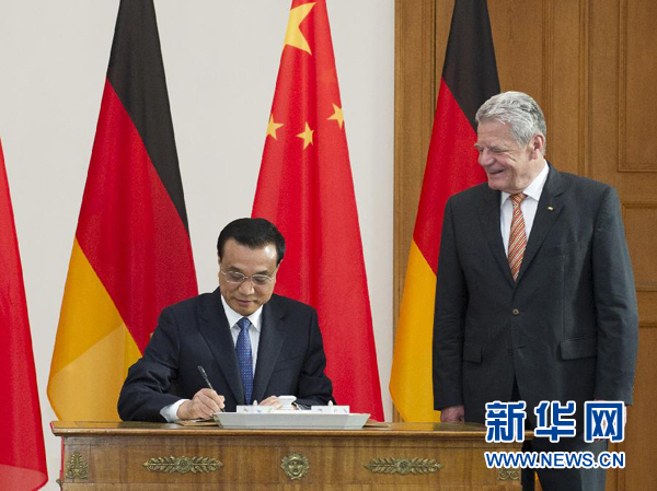 10月10日，國務(wù)院總理李克強在柏林會見德國總統(tǒng)高克。這是李克強總理在高克總統(tǒng)的陪同下在貴賓簿上簽字。 新華社記者 王曄 攝 