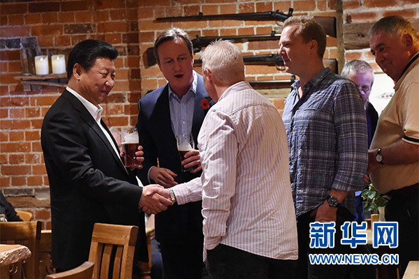 這是習(xí)近平與卡梅倫飲啤酒，并同當(dāng)?shù)孛癖娊徽劇Ｐ氯A社記者 饒愛民 攝